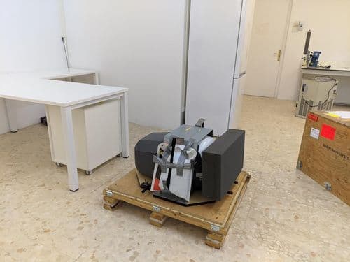 A person's hands unboxing a new 100 MHz benchtop NMR machine.